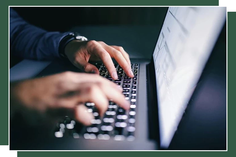 człowiek piszący na klawiaturze laptopa